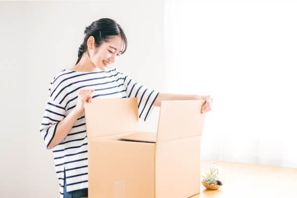 ダンボールを開ける女性