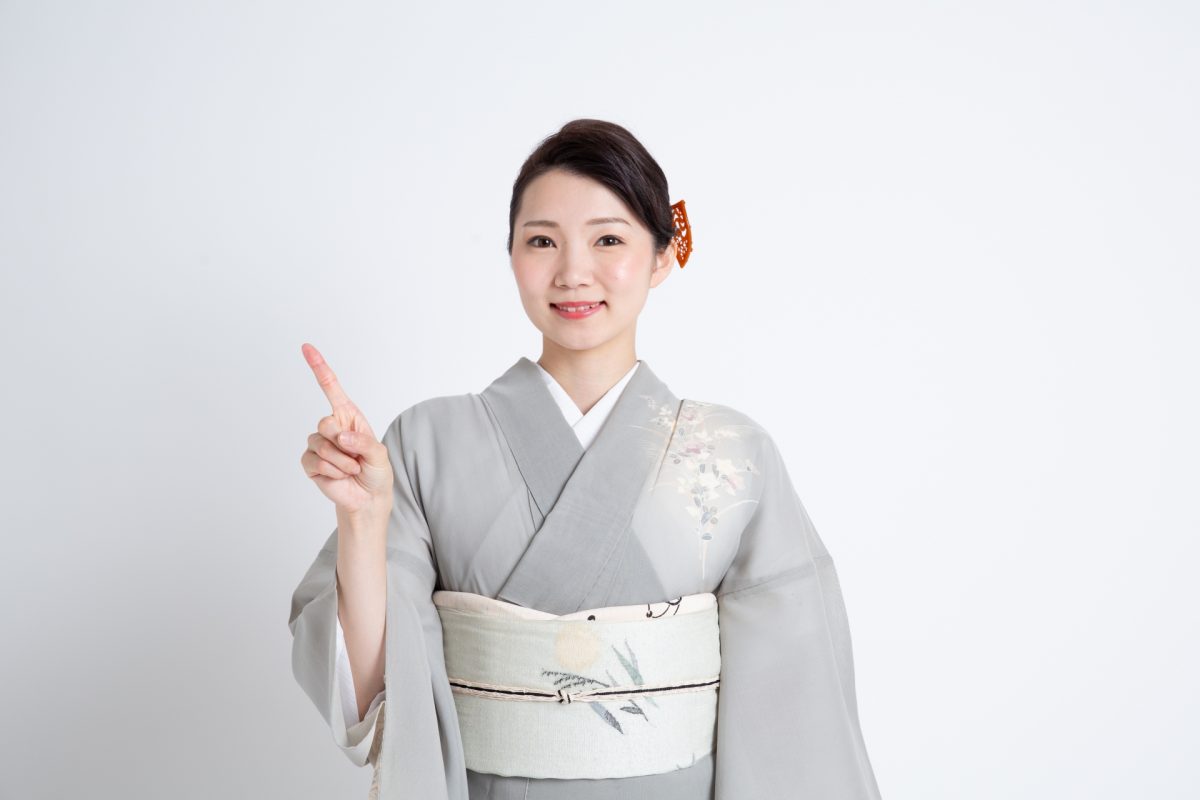 訪問着で指を指している女性
