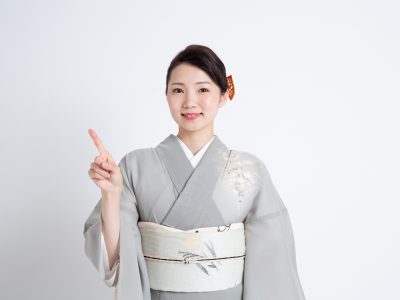 訪問着で指を指している女性