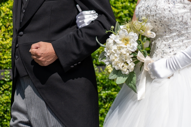 腕を組む新婦とその父親