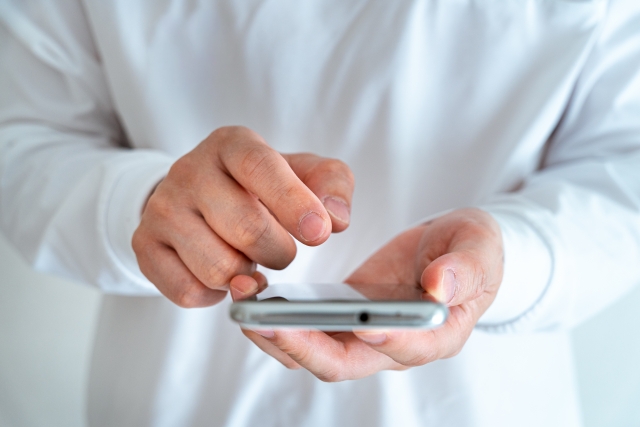 スマートフォンを持つ男性の手元のアップ